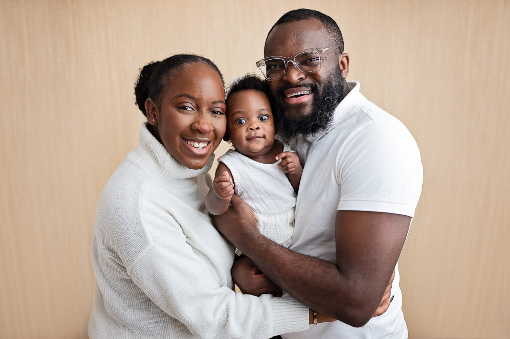 Smiling family with a baby during a professional baby photography session in Glasgow, captured by a family photographer