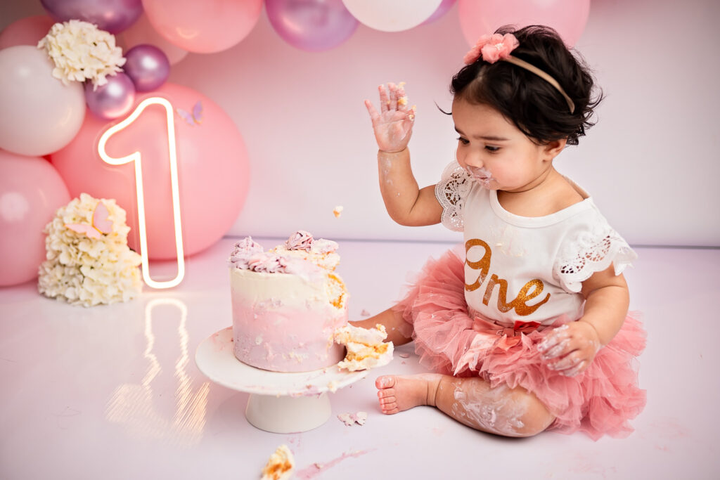 baby girl smashing her cake during a cake smash photoshoot with Ola Molik Photogrpahy