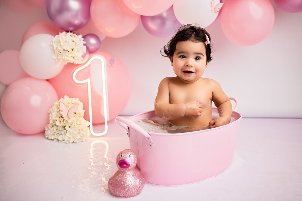 baby girl taking a tub bath during her cake smash photoshoot with Ola Molik Photography