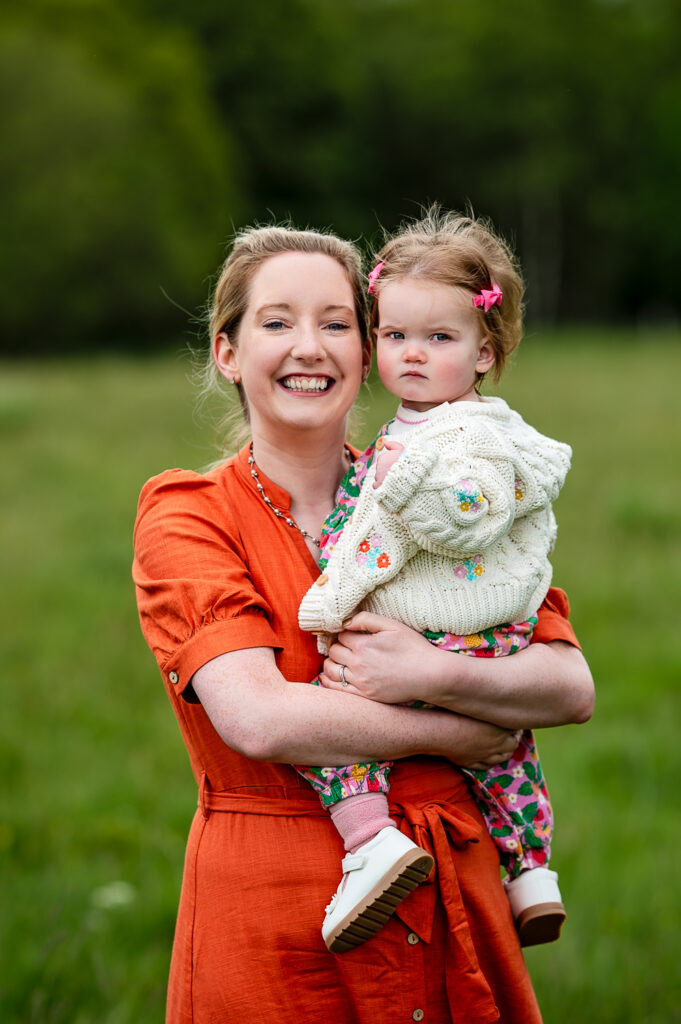 Mum and daughter smiling at the camera for a family photographer Ola Molik Photography