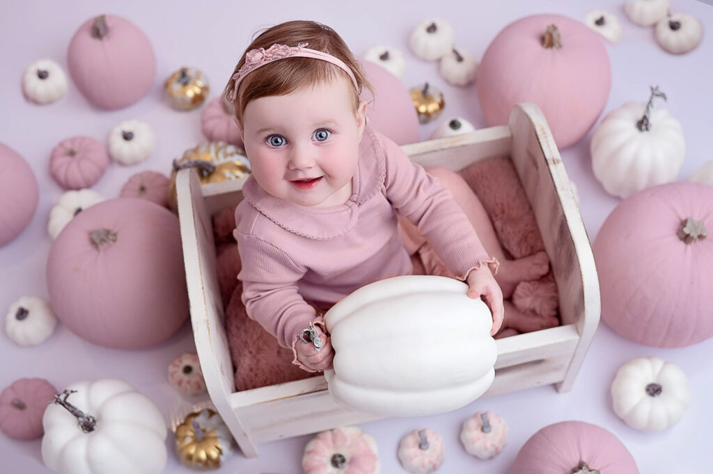 Baby holding a pumpkin during her mini photoshoot with Ola Molik Photography