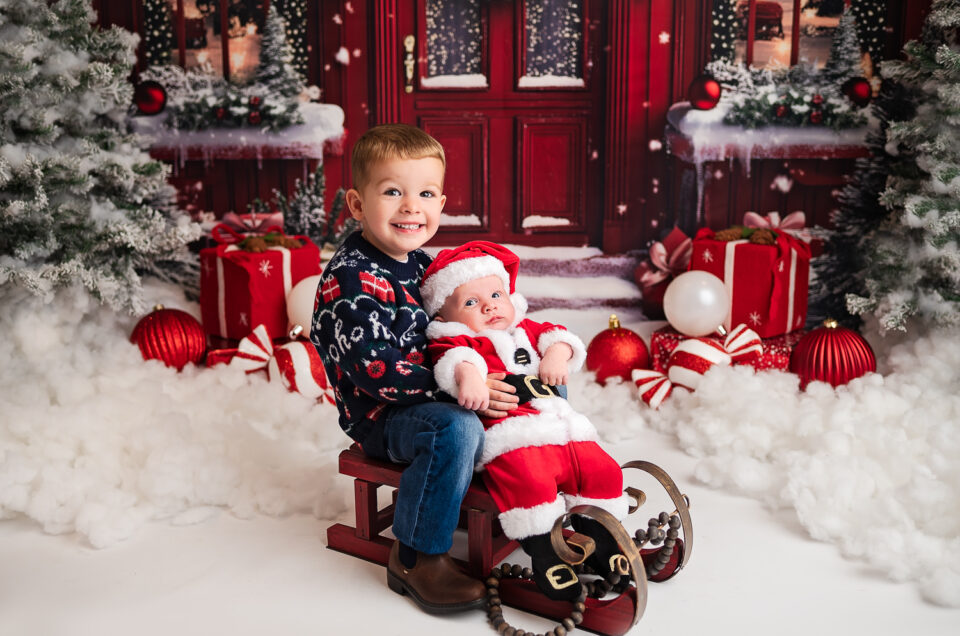 Boys siting at the sleigh and posing for a photographer Ola Molik Photography