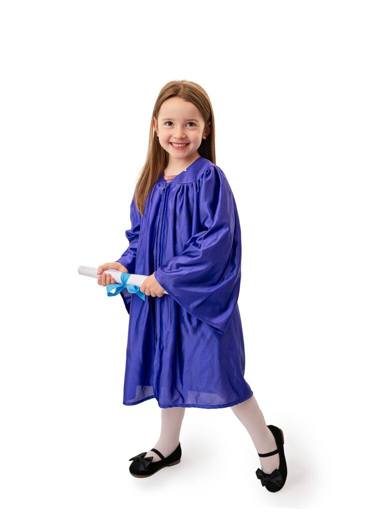 Nursery graduation portrait of smiling preschool girl wearing a blue graduation gown in a Glasgow photography studio