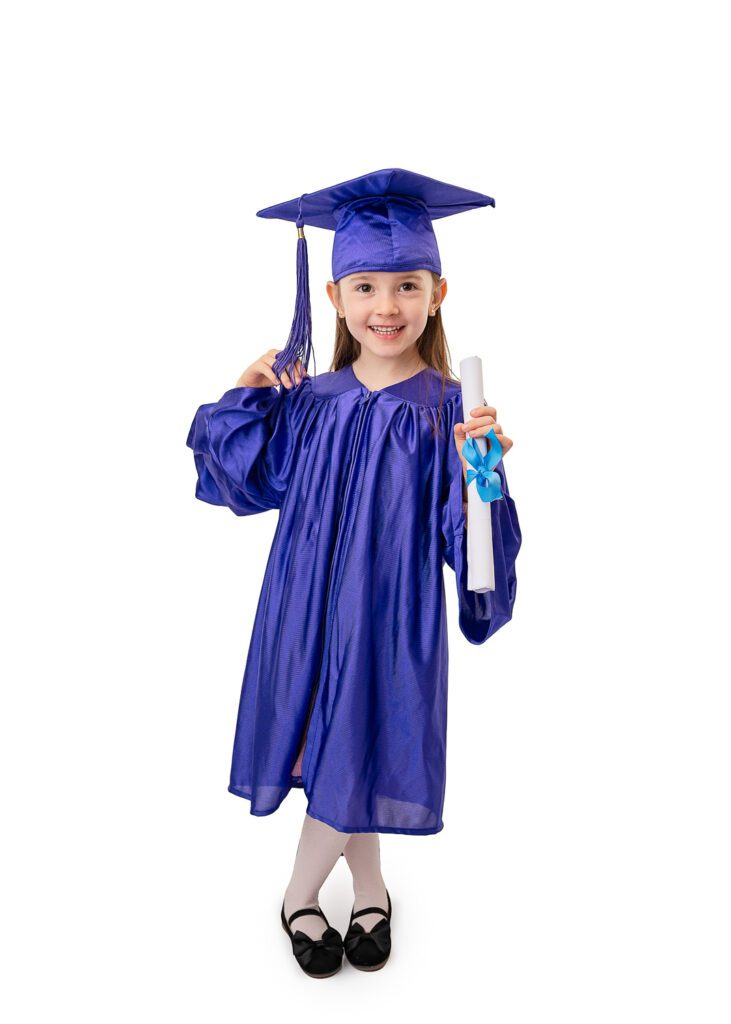 Nursery graduation portrait of smiling preschool girl wearing a blue graduation gown in a Glasgow photography studio