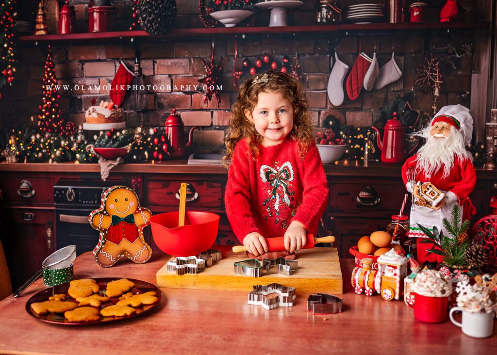 Christmas Kitchen photoshoot in Glasgow by Ola Molik Photography, featuring a young girl enjoying a festive baking-themed Christmas photography session with gingerbread cookies, Christmas decorations and colourful seasonal props. Christmas Mini Sessions for children and families in Glasgow and Clydebank.